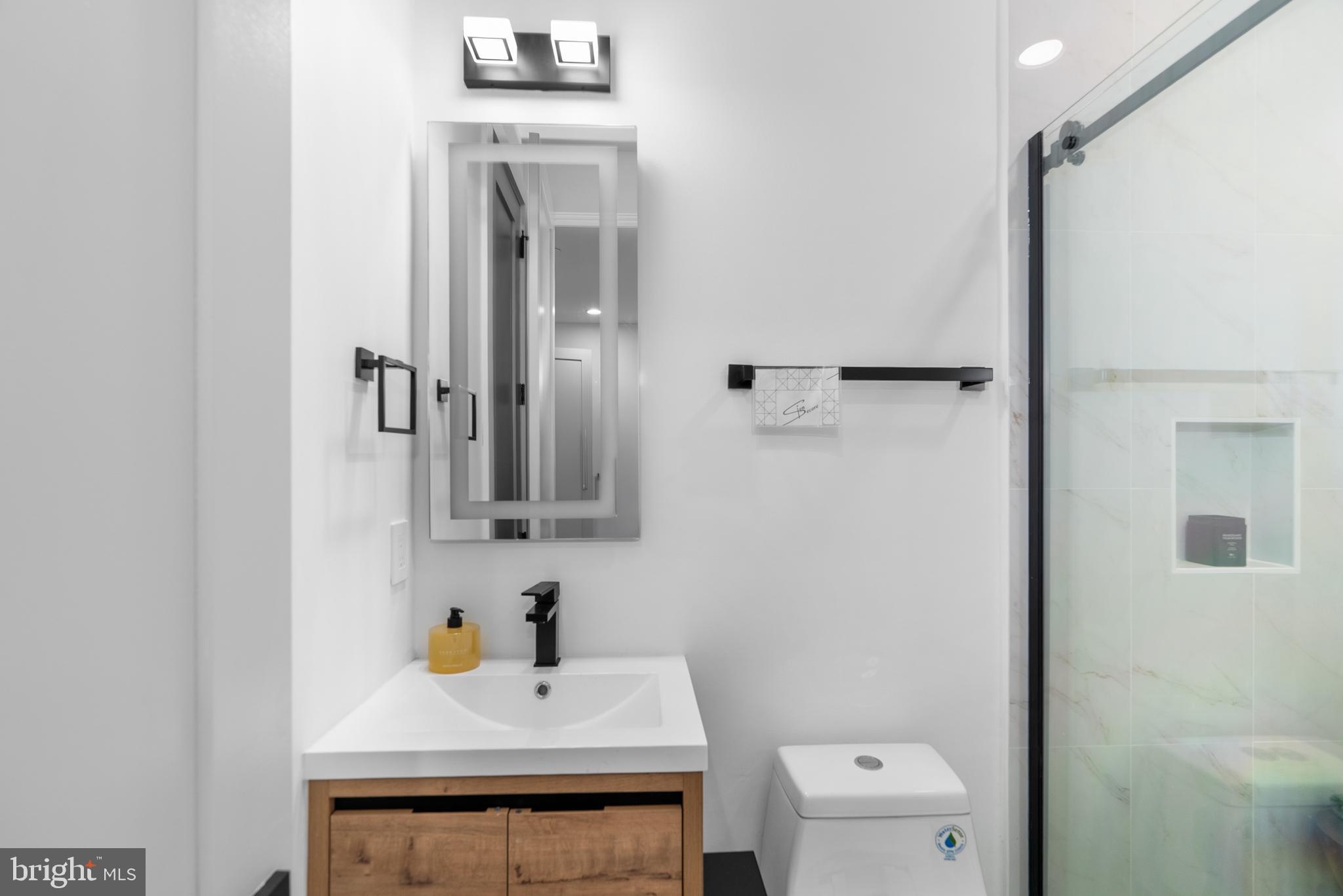 1140 Oates Street Northeast, Unit 101 Washington, DC 20002 - Photo 28 of 34 a bathroom with a sink a toilet and shower