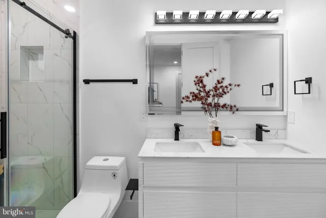 a bathroom with a sink vanity mirror and toilet