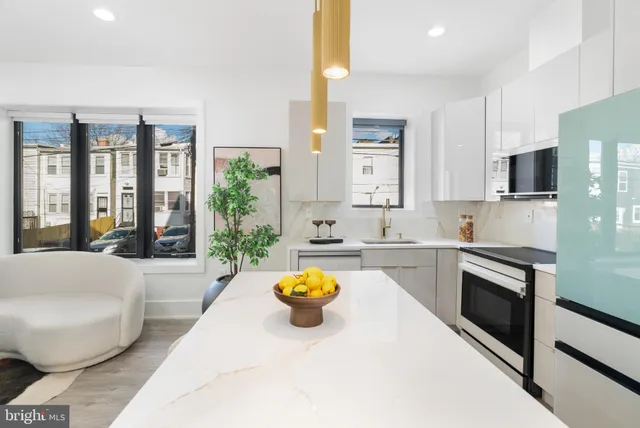 a kitchen with stainless steel appliances granite countertop a sink a stove top oven a granite counter tops and white cabinets