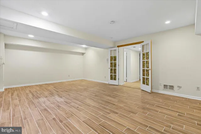 a view of an empty room with wooden floor