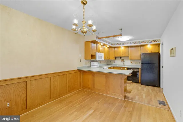 a view of a kitchen with a sink dishwasher a refrigerator with wooden floor