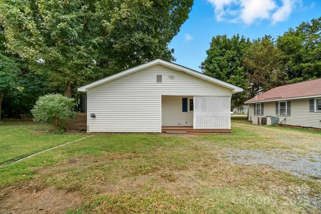 a view of a house with a yard and trees