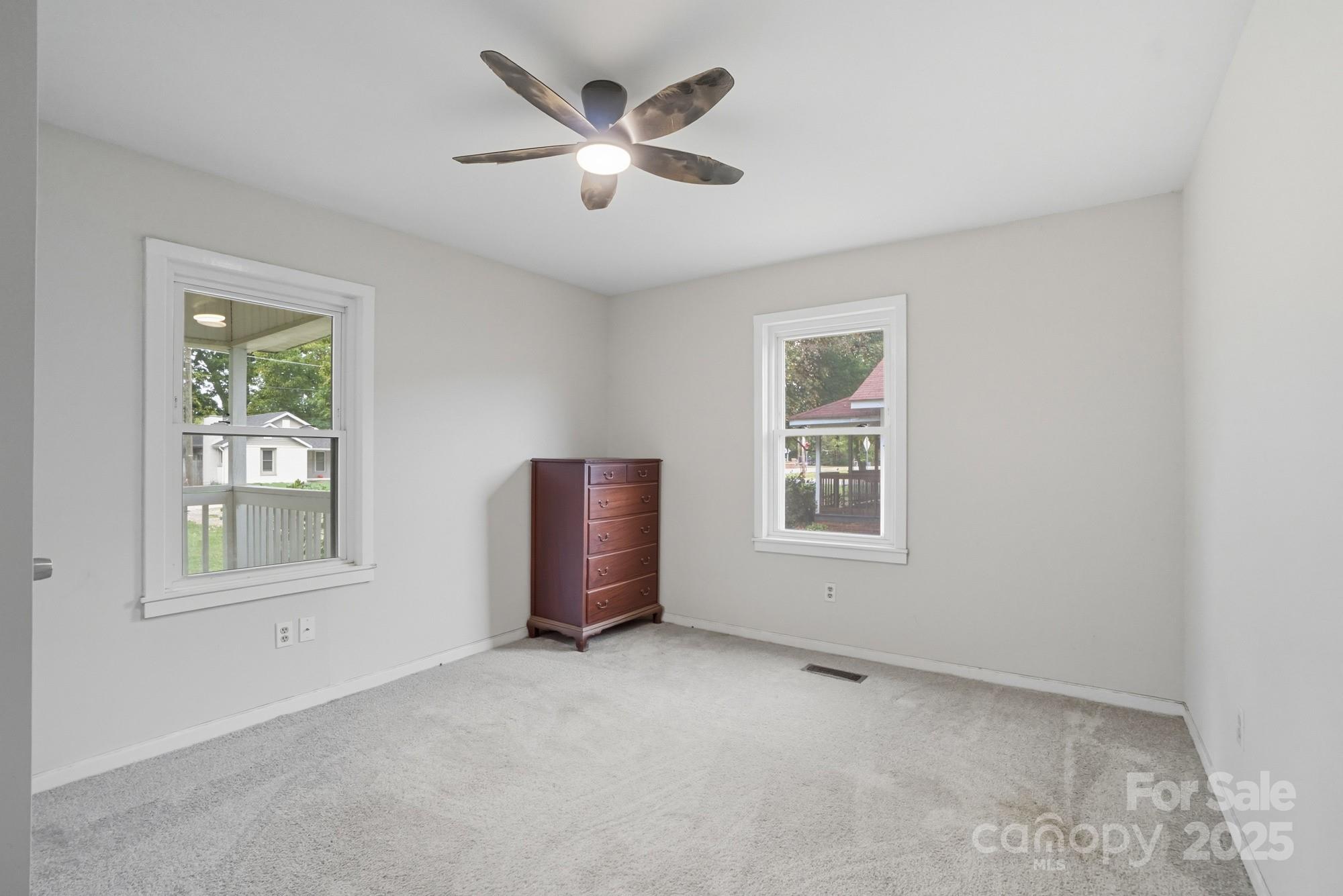 2729 South Ridge Avenue Concord, NC 28025 - Photo 9 of 19 an empty room with windows and ceiling fan