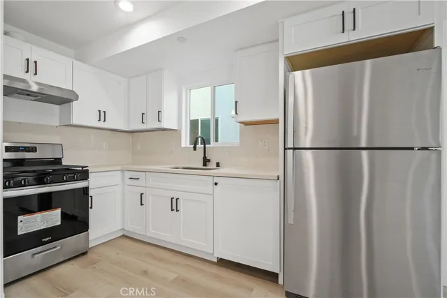 a kitchen with stainless steel appliances white cabinets and a refrigerator