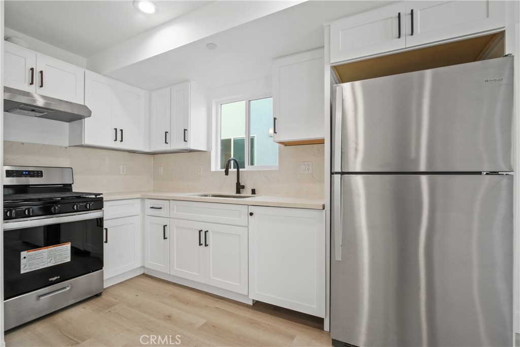 a kitchen with stainless steel appliances white cabinets and a refrigerator