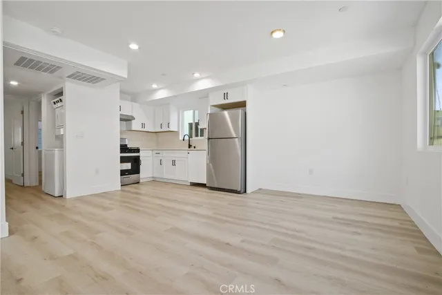 a view of a kitchen with a sink and a refrigerator