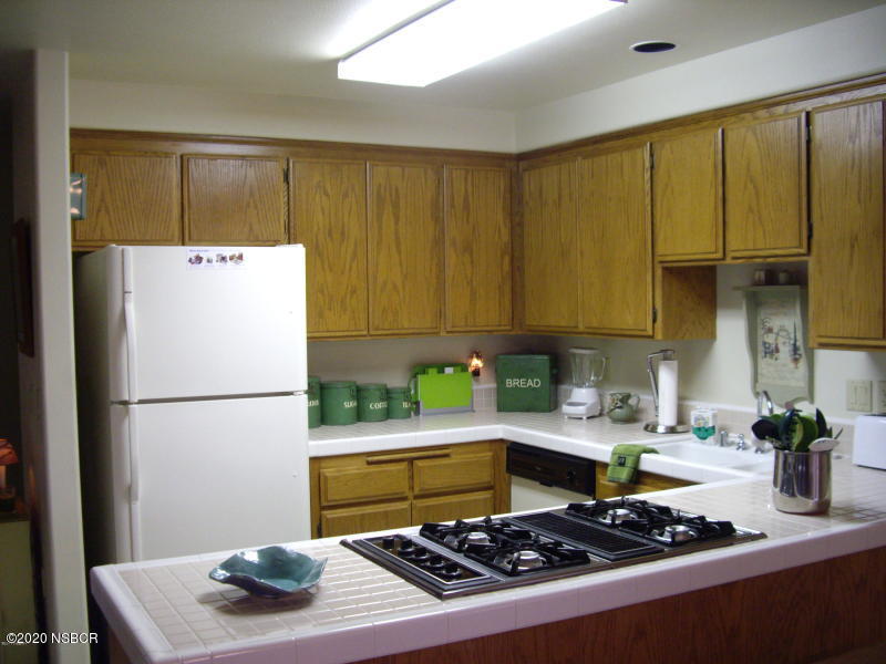 3165 Christopher Drive Lompoc, CA 93436 - Photo 19 of 52 a kitchen with a refrigerator a stove a sink cabinetry and a dining table