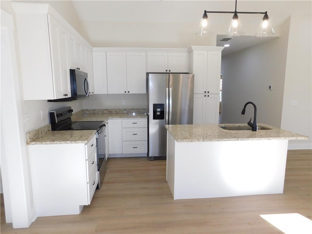 98 Elbert Gaddis Road Dahlonega, GA 30533 - Photo 13 of 38 a kitchen with kitchen island a sink stainless steel appliances and cabinets