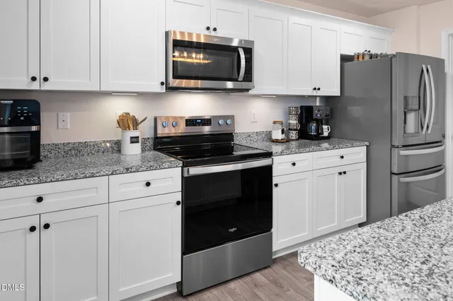 a kitchen with granite countertop sink cabinets and wooden floor