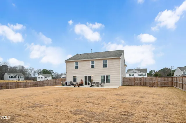 a view of a house with patio and a backyard
