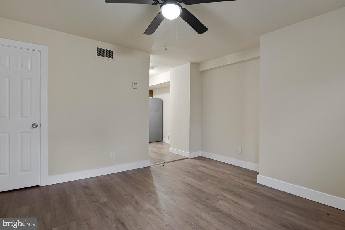 3427 B Street Southeast, Unit 1 Washington, DC 20019 - Photo 4 of 17 an empty room with wooden floor chandelier fan and closet area