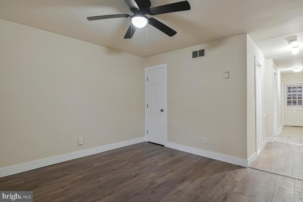 3427 B Street Southeast, Unit 1 Washington, DC 20019 - Photo 6 of 17 an empty room with wooden floor and ceiling fan