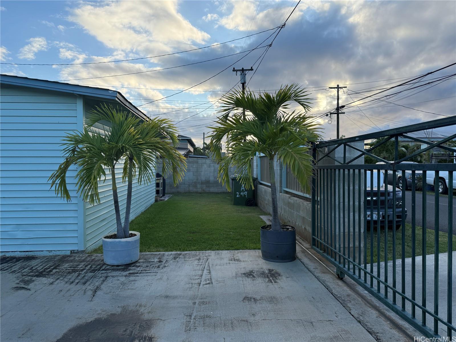 91-249 Ewa Beach Road Ewa Beach, HI 96706 - Photo 2 of 25 a palm tree sitting in front of a house with potted plants
