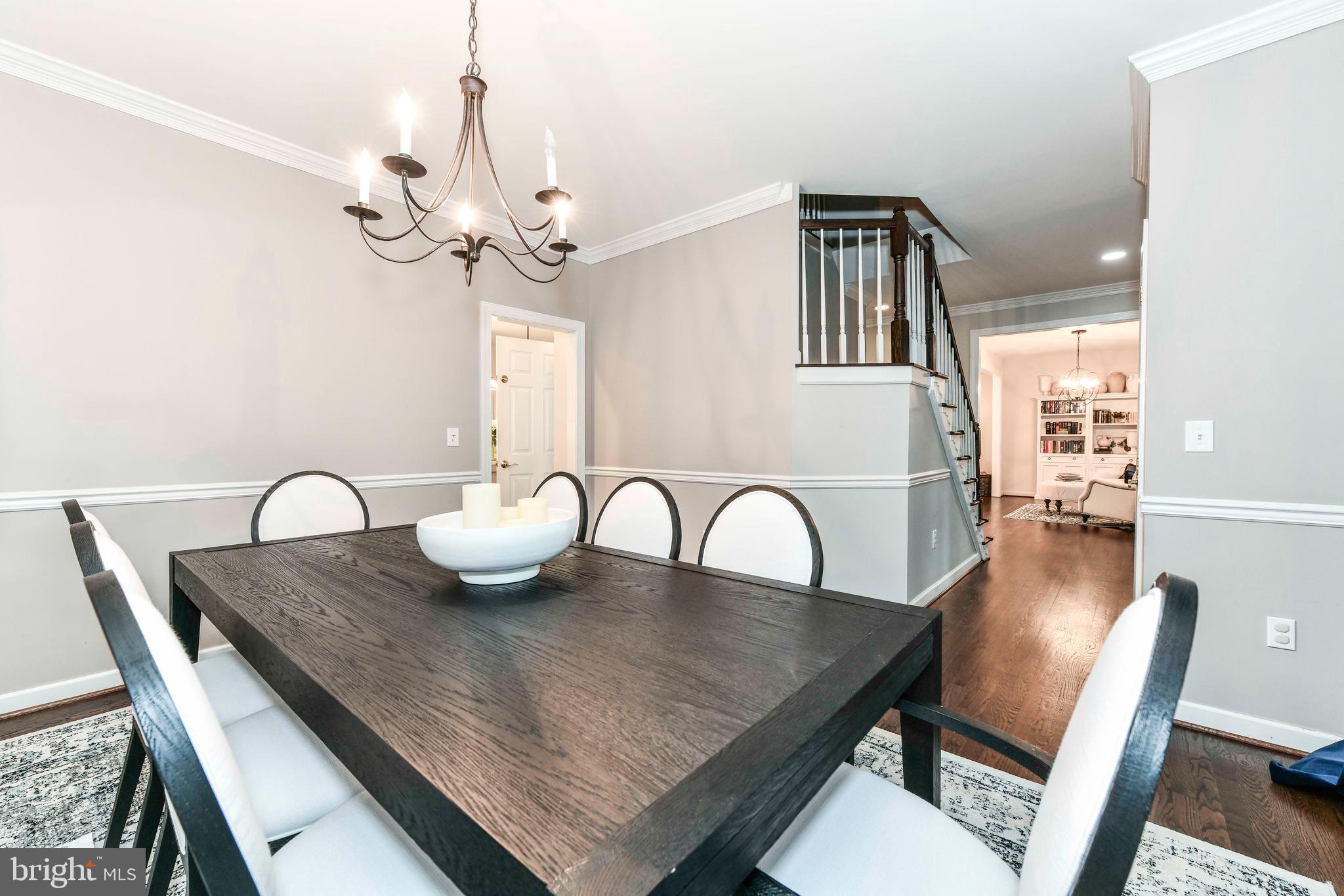 6866 Melrose Drive McLean, VA 22101 - Photo 12 of 42 a dining room with furniture a chandelier and wooden floor