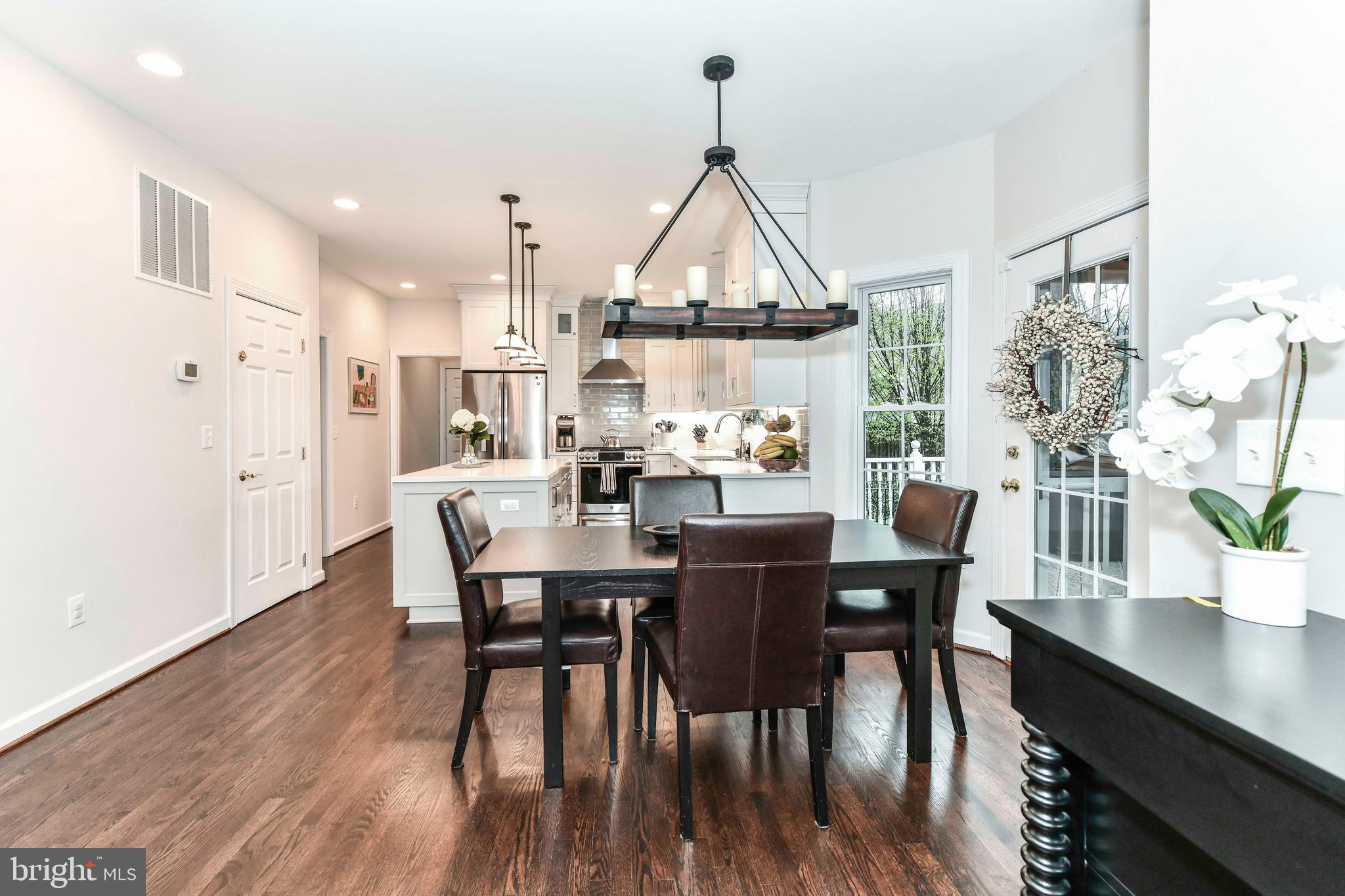 6866 Melrose Drive McLean, VA 22101 - Photo 13 of 42 a dining room with furniture a chandelier and wooden floor