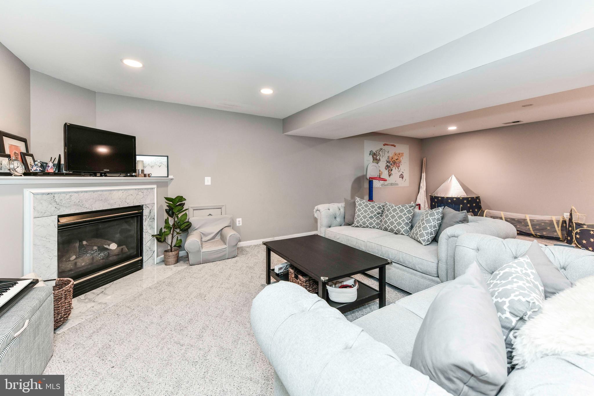 6866 Melrose Drive McLean, VA 22101 - Photo 30 of 42 a living room with furniture a fireplace and a flat screen tv