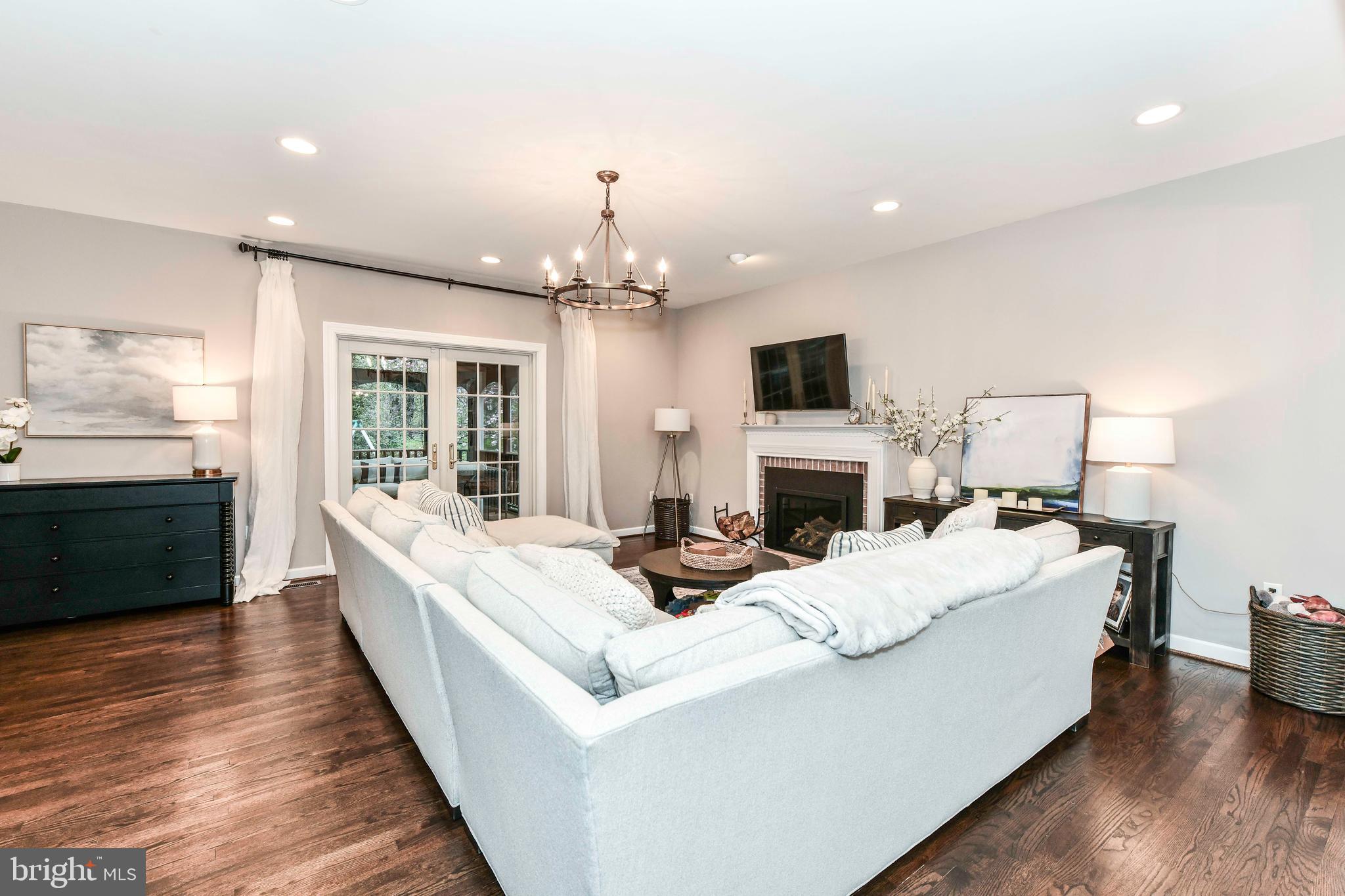 6866 Melrose Drive McLean, VA 22101 - Photo 9 of 42 a living room with a fireplace furniture a fireplace and a flat screen tv