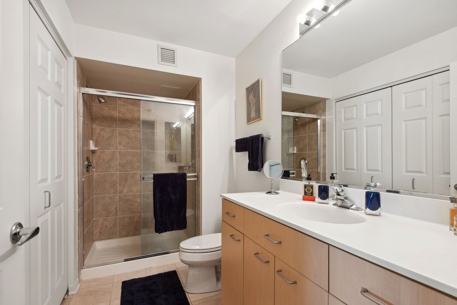 1640 Maple Avenue, Unit 1107 Evanston, IL 60201 - Photo 11 of 28 a bathroom with a sink a toilet a shower and a mirror