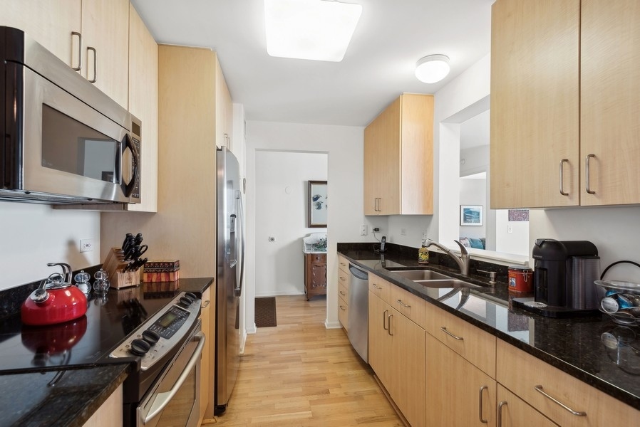 1640 Maple Avenue, Unit 1107 Evanston, IL 60201 - Photo 5 of 28 a kitchen with stainless steel appliances granite countertop a stove and a sink