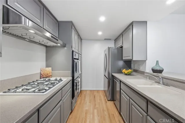 a kitchen with stainless steel appliances a sink stove and refrigerator