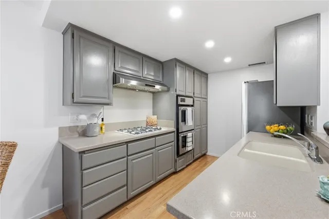 a kitchen with stainless steel appliances granite countertop a sink a stove and a refrigerator