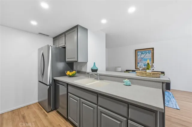 a kitchen with stainless steel appliances a sink and refrigerator