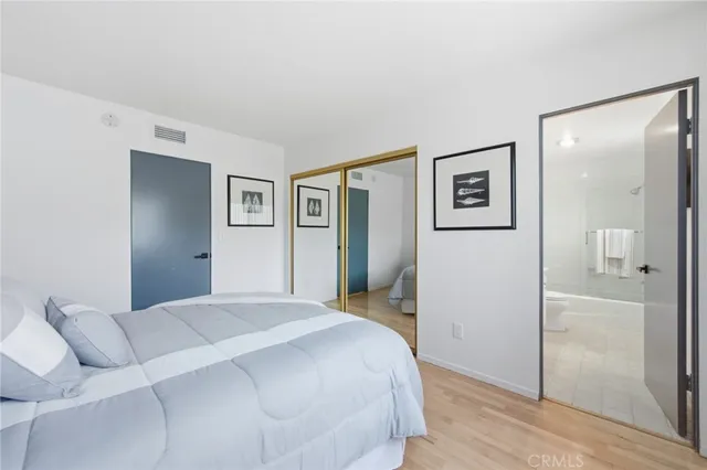 a bedroom with a bed and painting on the wall