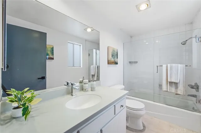 a bathroom with a granite countertop sink a toilet and a mirror