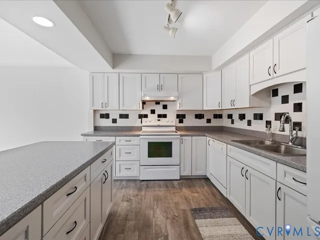 a kitchen with granite countertop white cabinets and white appliances