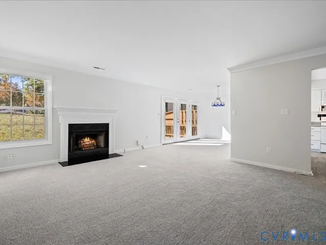 an empty room with a fireplace and window
