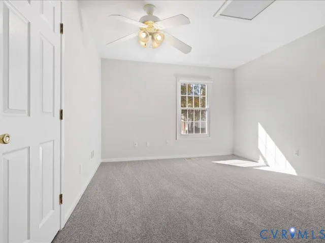 an empty room with a chandelier fan