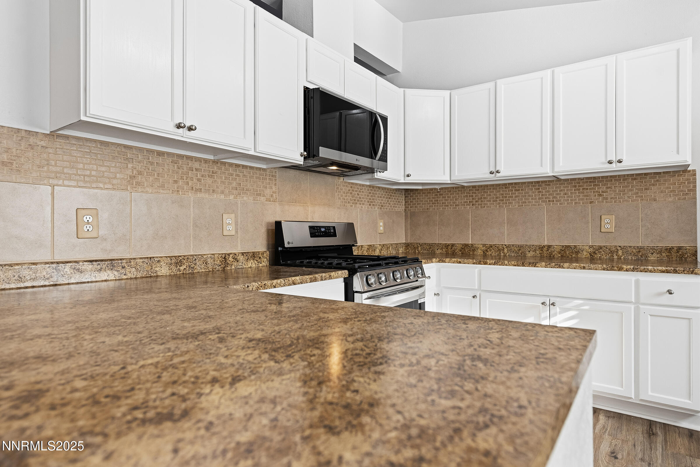 2650 Daffodil Way Reno, NV 89512 - Photo 12 of 22 a kitchen with stainless steel appliances granite countertop a sink a stove and white cabinets