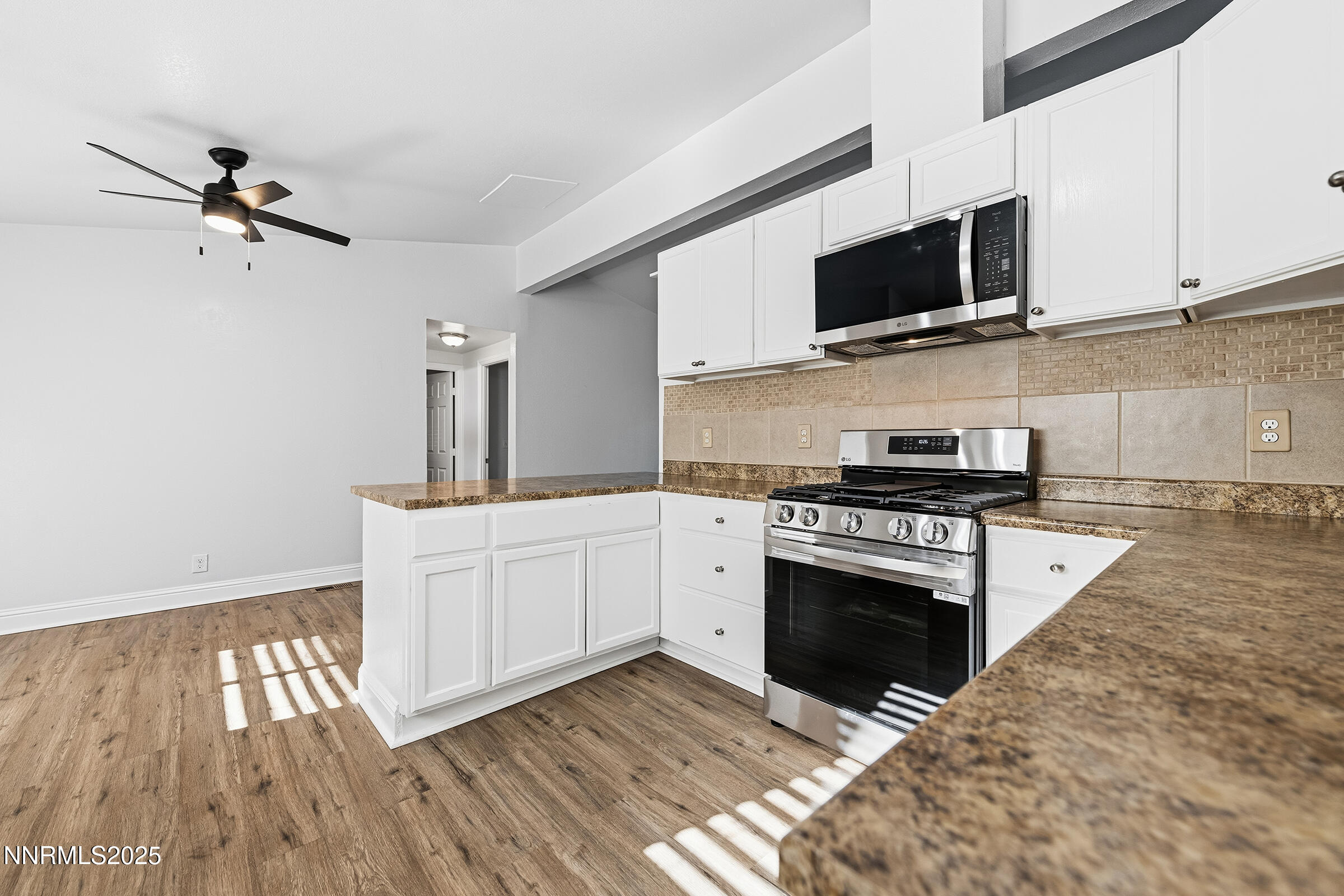 2650 Daffodil Way Reno, NV 89512 - Photo 14 of 22 a kitchen with stainless steel appliances white cabinets a stove a sink and a microwave