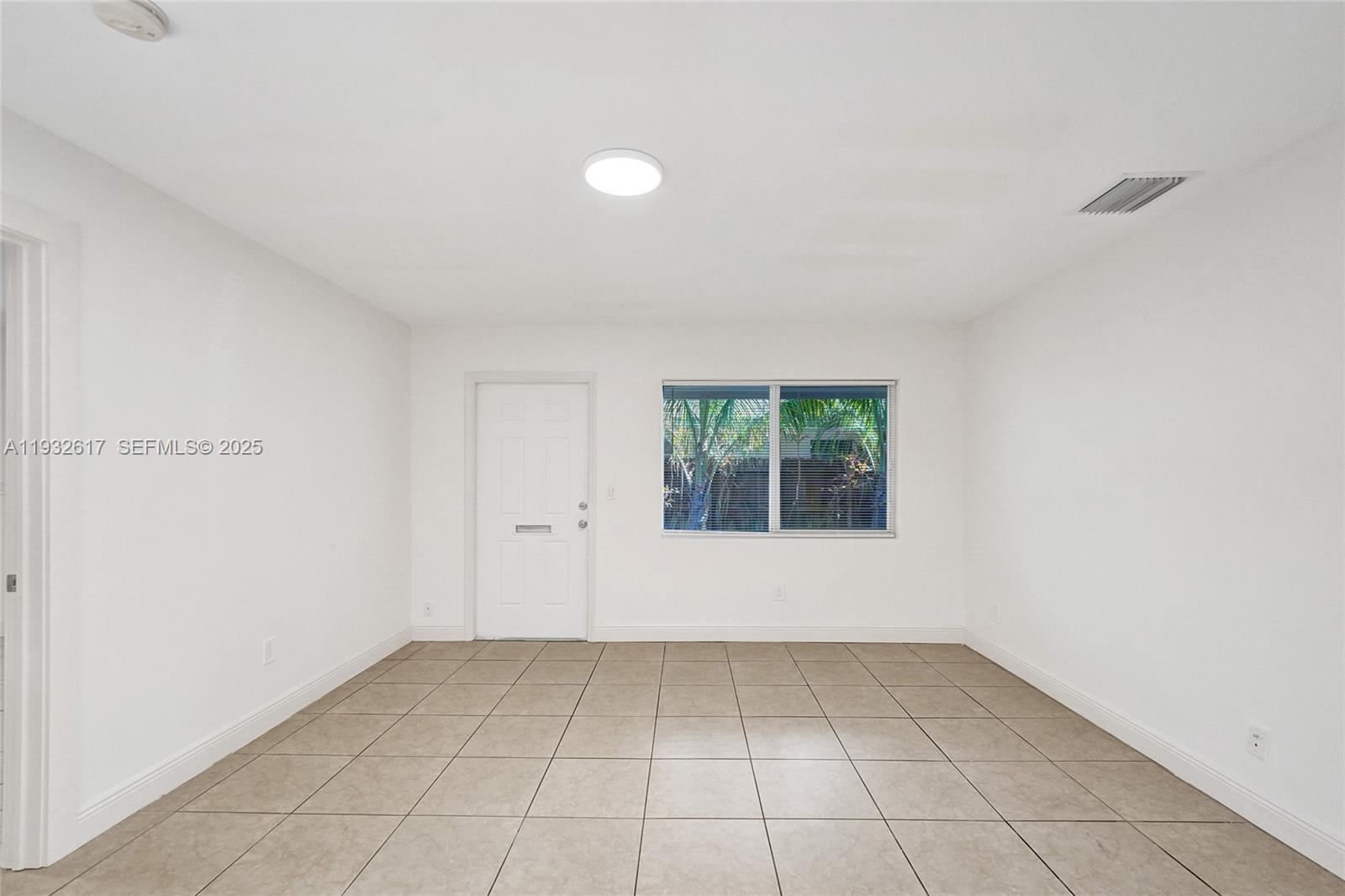 30 Southwest 8th Street, Unit 1 Hallandale Beach, FL 33009 - Photo 42 of 75 an empty room with a white walls and a window