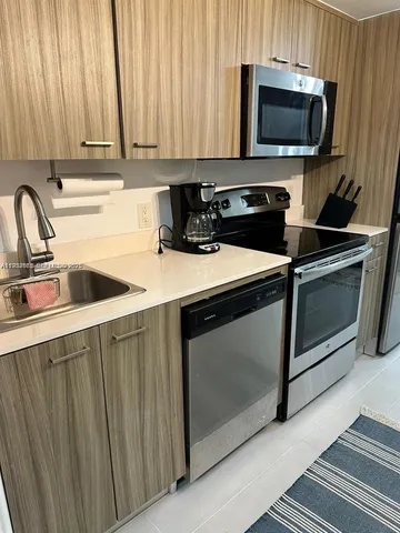 a kitchen with a stove a microwave and sink