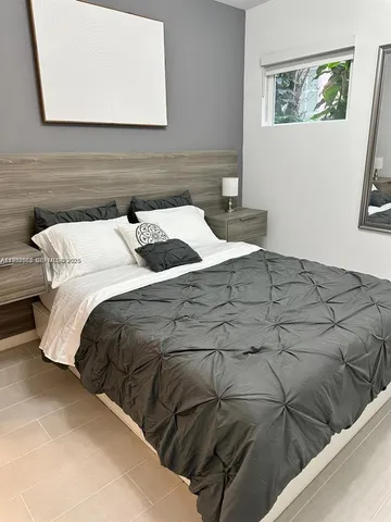 a bedroom with a bed and a painting on the wall