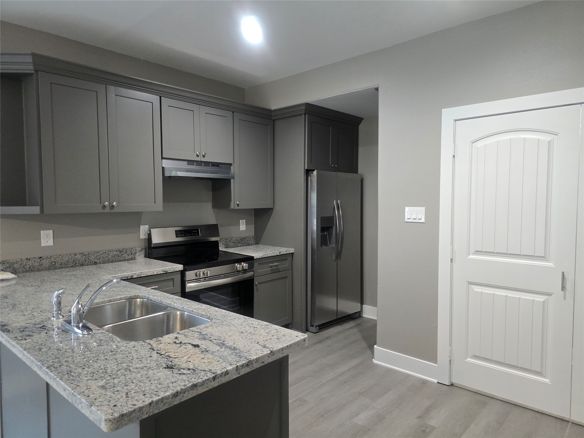 3516 Hunnicutt Street, Unit A Dayton, TX 77535 - Photo 2 of 4 a kitchen with a granite countertop sink refrigerator and cabinets