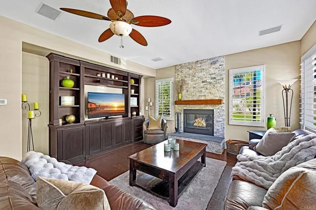 a living room with furniture a flat screen tv and a fireplace