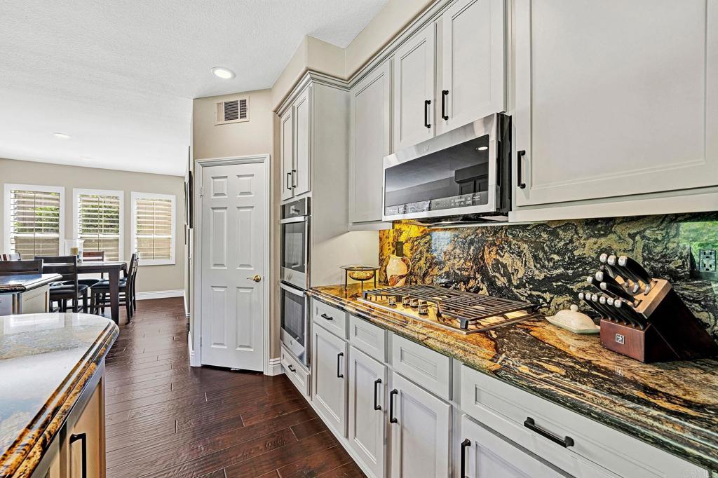 1463 Belmont Park Road Oceanside, CA 92057 - Photo 19 of 50 a kitchen with stainless steel appliances granite countertop a stove a sink and a microwave