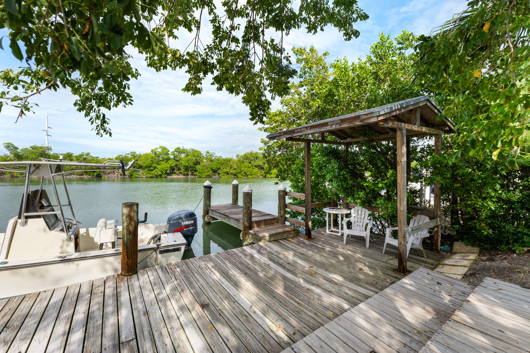 133 Sunset Drive Islamorada, FL 33036 - Photo 18 of 81 a view of a deck with chairs a barbeque with wooden floor and fence