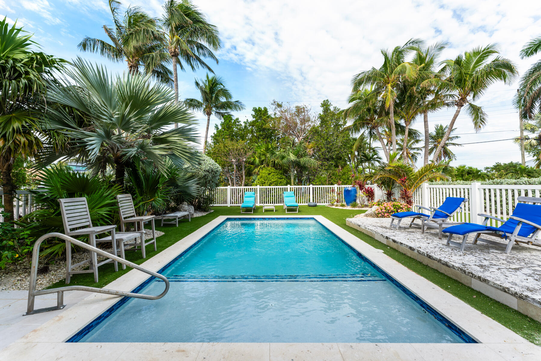 133 Sunset Drive Islamorada, FL 33036 - Photo 9 of 81 a view of a swimming pool with a lounge chair and palm trees