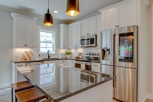 a kitchen with stainless steel appliances granite countertop a sink a stove and a refrigerator