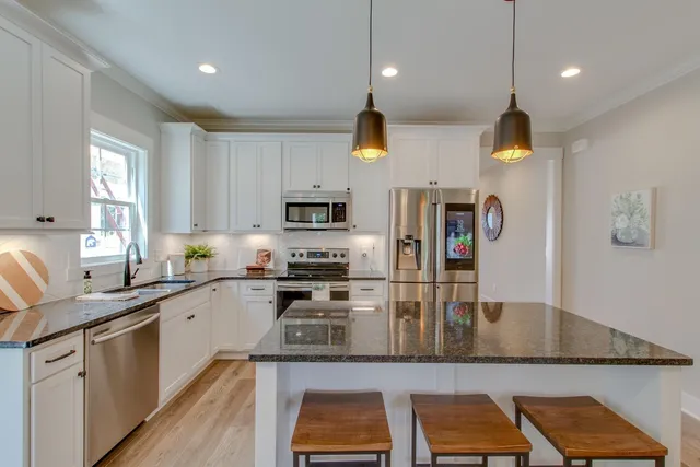 a kitchen with stainless steel appliances granite countertop a sink a stove and cabinets