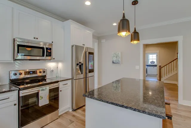 a kitchen with a sink a counter top space cabinets and stainless steel appliances