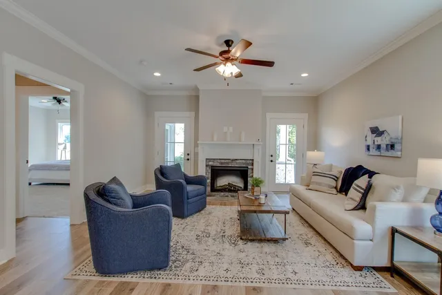 a living room with furniture a fireplace and a ceiling fan