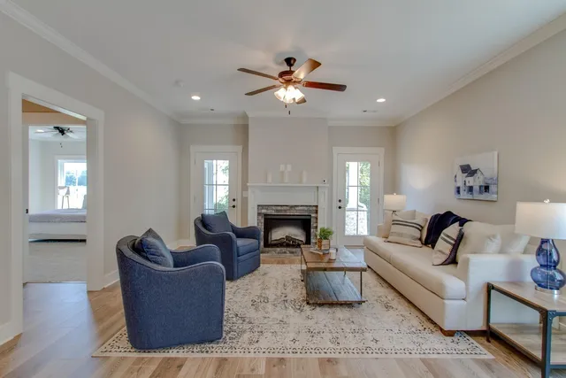 a living room with furniture a fireplace and a chandelier