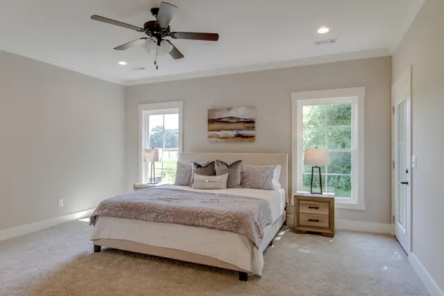 a bedroom with a bed a chandelier and a window