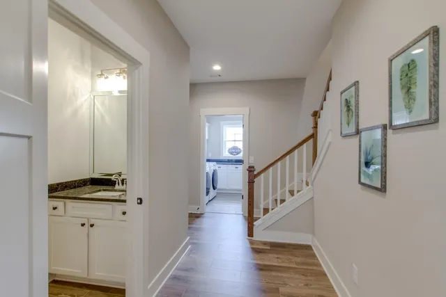 a view of a hallway with wooden floor and staircase