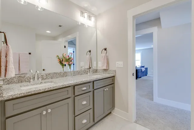 a bathroom with a granite countertop sink double and mirror