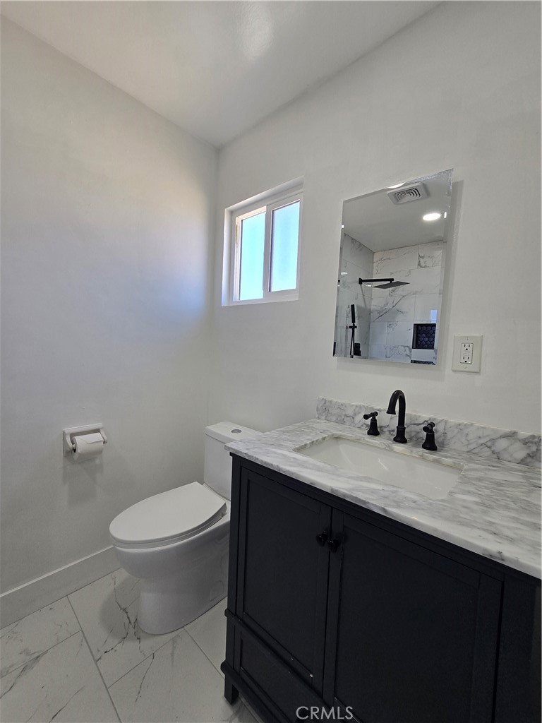 3404 Planz Road Bakersfield, CA 93309 - Photo 18 of 23 a bathroom with a granite countertop sink a toilet and a mirror